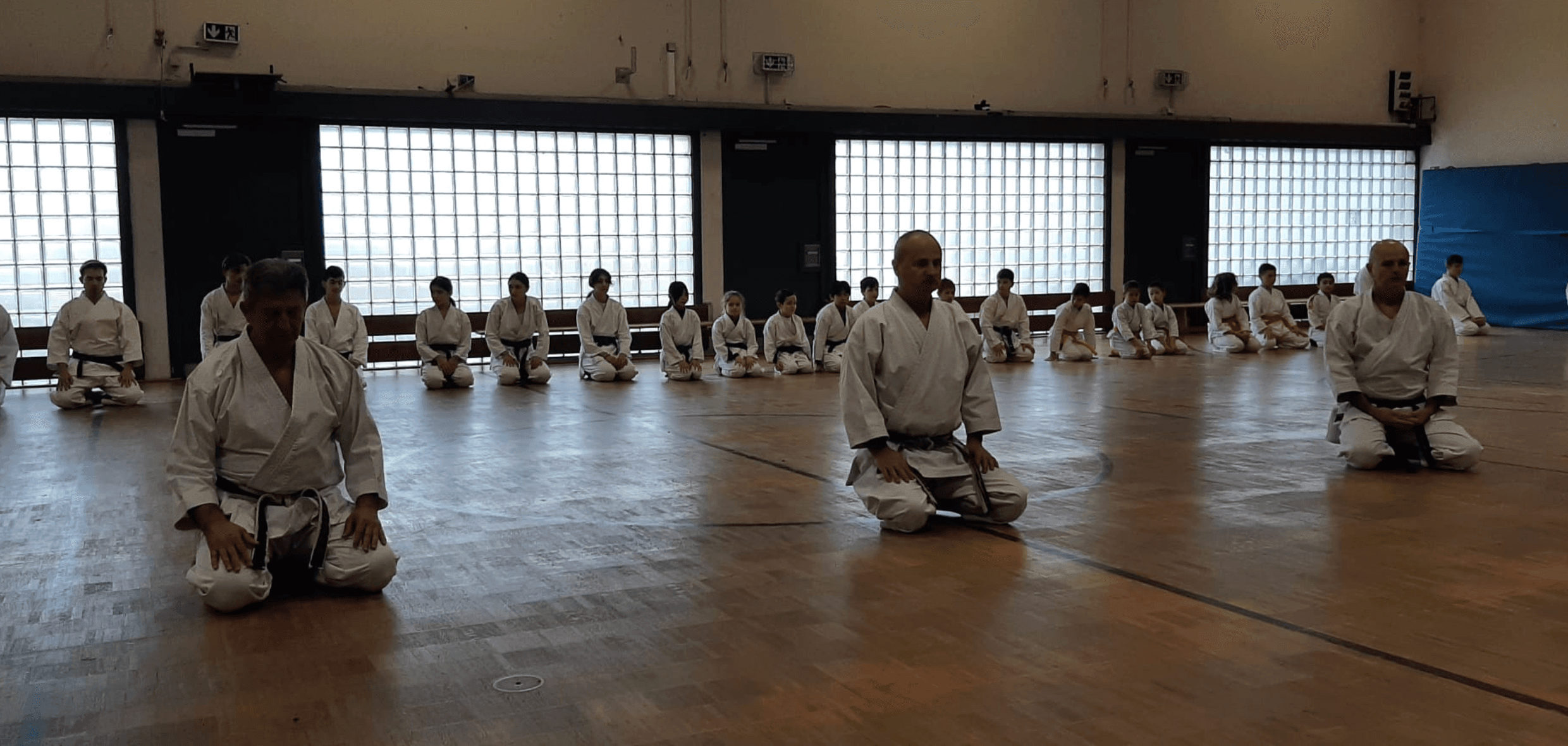 Children and adults practicing karate training in Neuhausen dojo